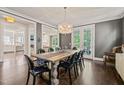 Elegant dining room with hardwood floors, a large chandelier, and view to living room at 129 Ruskin Dr, Chapel Hill, NC 27516