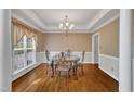 Elegant dining room featuring a glass table, decorative wallpaper, hardwood floors, and a large window at 1325 Red Brick Rd, Garner, NC 27529