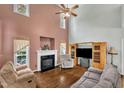 Cozy living room with a fireplace, high ceilings, hardwood floors, and comfortable seating, perfect for relaxation at 1325 Red Brick Rd, Garner, NC 27529