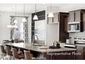 Modern kitchen featuring a large island with bar seating, pendant lights, and stainless steel appliances at 142 Benson Village Dr # 82, Benson, NC 27504