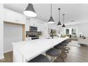 A well-lit kitchen features a large island with pendant lighting and seating, flowing into the living space at 142 Benson Village Dr # 82, Benson, NC 27504