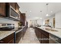 Elegant kitchen showcases stainless appliances, dark wood cabinets, and a view into the living room at 142 Benson Village Dr # 82, Benson, NC 27504