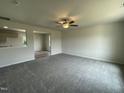 Expansive living room featuring neutral carpet, a ceiling fan and smooth walls, offering a cozy atmosphere at 159 Coharie Dr, Lillington, NC 27546