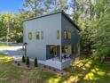 Gray home with a modern, minimalist design, showcasing a cozy covered porch and well-maintained lawn at 160 Daphine Dr, Hillsborough, NC 27278