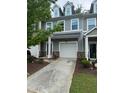 Inviting townhome showcasing a one-car garage and manicured landscaping at 1671 Holly Grove Way, Durham, NC 27713