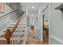 Hallway with stairs and hardwood flooring, with artwork and light green walls at 1813 Carrington Dr, Raleigh, NC 27615