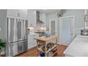 Bright kitchen with stainless steel appliances, tile backsplash, island and hardwood floors at 1813 Carrington Dr, Raleigh, NC 27615