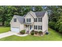 Charming two-story home with an attached two-car garage, set on a manicured lawn with shrubbery at 185 Keller Dr, Clayton, NC 27520