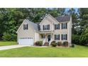 Attractive two-story home boasting mature landscaping, a two-car garage, and a welcoming facade at 185 Keller Dr, Clayton, NC 27520