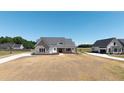 Eye-level exterior shows a grey-roofed house with a stone accent wall and a large, unfinished yard at 188 Banner Elk Rd, Benson, NC 27504