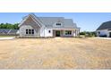 Eye-level exterior of house with stone accent wall and covered porch, shows large, unfinished yard at 188 Banner Elk Rd, Benson, NC 27504