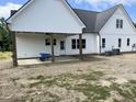 New construction home features covered patio with ceiling fan and backyard at 188 Banner Elk Rd, Benson, NC 27504