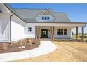 Inviting front entrance with a beautifully landscaped walkway, elegant front door, and charming covered porch at 188 Banner Elk Rd, Benson, NC 27504