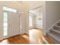 Bright and inviting foyer with gleaming hardwood floors, staircase access, and a view into the adjacent dining room at 203 Chilcott Ln, Apex, NC 27502