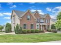 Attractive red brick and siding home with lush green lawn and neatly trimmed hedges at 208 Bridle Boast Rd, Cary, NC 27519