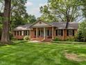 Charming brick home with a manicured lawn, mature trees and black shutters exudes curb appeal at 2228 Walker Ave, Burlington, NC 27215