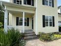 View of front porch with white railing, address 2377 on the window, and partial black door at 2377 Vinson Rd, Clayton, NC 27527