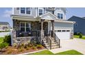 Charming front porch with stone accents, wrought iron railings, and comfortable seating at 272 High Woods Rdg, Chapel Hill, NC 27517