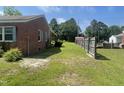 Fenced yard features lush green grass and mature trees, providing privacy and a serene outdoor space at 3301 Amherst Rd, Rocky Mount, NC 27804