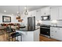 Modern kitchen features granite counters, stainless steel appliances, and white cabinetry with eat in bar at 352 Church St # 53, Wendell, NC 27591