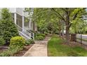 Charming two-story home with a covered front porch, red front door, landscaped yard, and brick and siding exterior at 3923 Napa Valley Dr, Raleigh, NC 27612