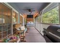 Inviting screened porch featuring hanging bed and cozy seating area at 4144 Fairport Rd, Kittrell, NC 27544