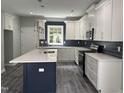 Modern kitchen with white cabinets, dark backsplash, and stainless steel appliances at 431 Mayview Dr, Creedmoor, NC 27522