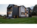 Modern home with a balcony, striking color scheme, and well-maintained lawn for curb appeal at 500 Grigsby Ave, Holly Springs, NC 27540