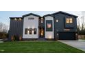 Contemporary two-story home with a dark garage door, modern siding, and manicured lawn at 500 Grigsby Ave, Holly Springs, NC 27540