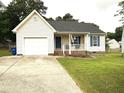 Charming single-story home featuring a front porch, attached garage, and well-maintained lawn at 5316 Tanglewood Pine Ln, Raleigh, NC 27610