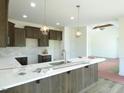 Lovely kitchen boasting granite countertops, dark wood cabinets, pendant lighting, and stainless steel sink at 614 Tart Town Rd, Dunn, NC 28334