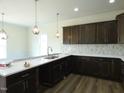 Modern kitchen features dark wood cabinets, white countertops, stylish pendant lighting, and wood-look floors at 614 Tart Town Rd, Dunn, NC 28334