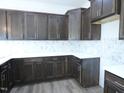 Well-lit kitchen showcases dark wood cabinets, white countertops, and a decorative backsplash at 614 Tart Town Rd, Dunn, NC 28334