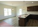 Kitchen and breakfast nook showcasing modern pendant lights, dark cabinets and luxury vinyl tile flooring at 614 Tart Town Rd, Dunn, NC 28334