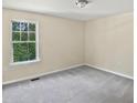 An empty bedroom features a cozy carpet and natural light from the window at 617 Hiddenbrook Dr, Durham, NC 27703