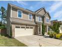 Charming two-story home featuring a spacious two-car garage, inviting front porch, and lush landscaping at 617 Hiddenbrook Dr, Durham, NC 27703