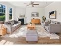 Bright living room with a fireplace, large windows, and neutral tones and modern decor at 617 Hiddenbrook Dr, Durham, NC 27703
