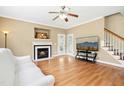 Spacious living room features a fireplace, backyard access, hardwood floors, and access to stairs at 634 Cotton Brook Dr, Fuquay Varina, NC 27526
