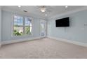 A bright bedroom with a large window, balcony door, neutral carpet and blue walls at 735 Portstewart Dr, Cary, NC 27519
