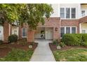 A ground-level entrance to a condo building featuring brick accents and manicured landscaping at 735 Portstewart Dr, Cary, NC 27519
