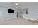 Spacious living room featuring neutral carpet, light blue walls, and a modern ceiling fan at 735 Portstewart Dr, Cary, NC 27519