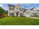 Inviting two-story home with a lush green lawn, showcasing a two-car garage and classic architectural design at 7612 Vista Del Rey Ln, Raleigh, NC 27613