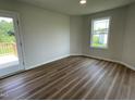 Cozy bedroom with wood-look flooring, access to a porch and a bright window at 81 Coharie Dr, Lillington, NC 27546
