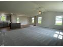 Spacious open concept area featuring plush carpet, stylish finishes and large windows overlooking green backyard at 81 Coharie Dr, Lillington, NC 27546