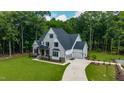 Aerial view of a two-story home with a sprawling driveway, attached garage, and landscaped front yard at 91 Ivy Ridge Rd, Chapel Hill, NC 27516