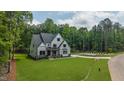 Expansive front yard showcasing a two-story home with a long driveway and tree-lined backdrop at 91 Ivy Ridge Rd, Chapel Hill, NC 27516
