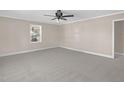 Spacious living room features neutral carpeting and a ceiling fan at 102 S College Ave, Kenly, NC 27542