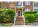 Inviting front entrance with brick steps, white railings, and lush green bushes at 102 Winged Foot Ct, Mebane, NC 27302