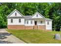 Beautiful two-story home featuring brick accents, white siding, and a covered front porch at 10304 Stallion Way, Bahama, NC 27503