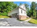 Spacious garage with unique doors, brick foundation, and a paved driveway at 10304 Stallion Way, Bahama, NC 27503